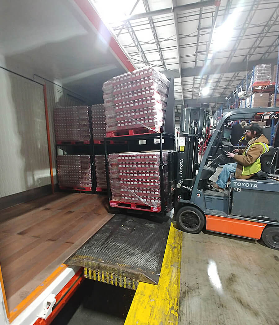 Pallets being moved to a rail car by a forklift ooperator